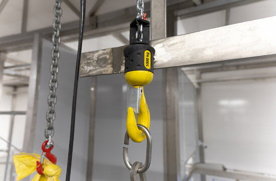 industrial crane hook indoors cold storage room freezers, lifting weights meat in an abattoir, industrial systems
