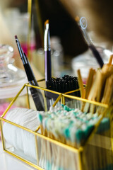 Professional brow artist shaping and styling eyebrows for a client in beauty salon, close-up of hands using tweezers and brush, beauty treatment and makeup service concept.