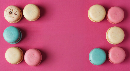 Fototapeta premium frame of delicious French macaroons on pink background, panoramic shot