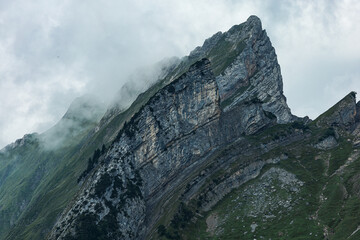 Sharp and rugged rocky mountain peaks rising above alpine slopes near Seealpsee in the Swiss Alps,...