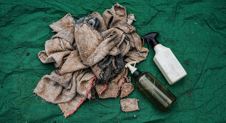 top view of rags and spray bottle for house cleaning on green