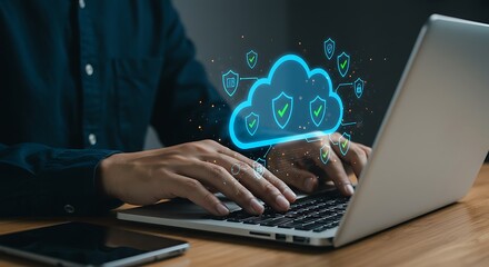 Man typing on laptop with glowing blue cloud computing icon above
