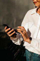 Young businesswoman using smartphone, focused on mobile device, modern office environment,...