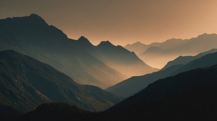 Moody dramatic mountain range with layered fog and warm sunset light.