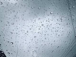 Raindrops on window against defocused blurred background. High quality photo of raindrops on his car window.