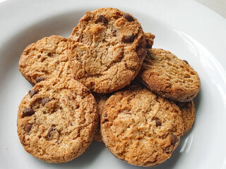 chocolate chip cookies on a white plate with a light background