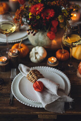 Beautiful seasonal decorated Thanksgiving table for cozy family dinner or fall luxury countryside wedding. Elegant beautiful setting for holiday event, party, reception. Wineglasses and fancy dishes.