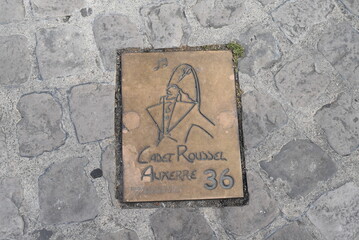 Bronze scellée dans le sol, à léffigie du Cadet Roussel, marquant une étape d'un circuit de découverte du patrimoine de la ville d'Auxerre.