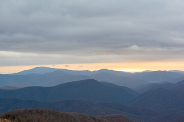 A breathtaking autumn sunrise where golden mountain slopes blaze with fall colors against the deep blue dawn sky.