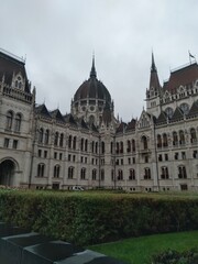 Naklejka premium The front of the Hungarian Parliament Building in Budapest, Hungary, showcases its world-famous neo-Gothic architecture. Decorative spires, pointed arches, and sculpted statues adorn the facade, makin