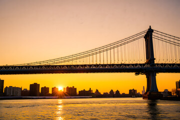 Majestic suspension bridge at golden hour over cityscape skyline sunset