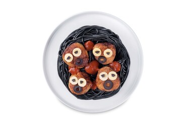 Meatballs with black pasta in the plate for Halloween on a white isolated background