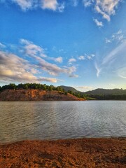 Scenic Lake Shore with Blue Sky and Clouds
