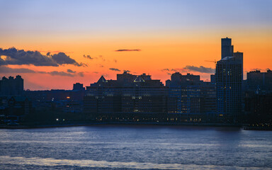 Jersey City skyline silhouette from New York, dramatic sunset over Hudson River