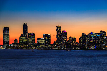 Jersey City skyline silhouette from New York, dramatic sunset over Hudson River