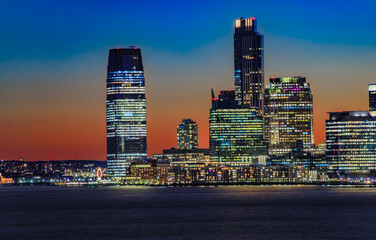Jersey City skyline silhouette from New York, dramatic sunset over Hudson River