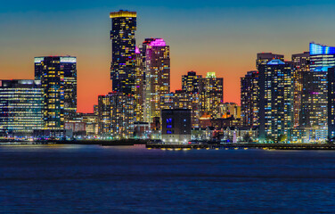 Jersey City skyline silhouette from New York, dramatic sunset over Hudson River