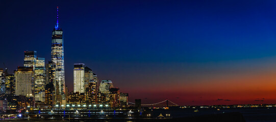 New York City downtown skyline at a dramatic sunset over the Hudson River, USA