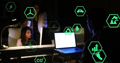 Male coworker typing laptop and female coworker entering with coffee pointing at eco metric icons