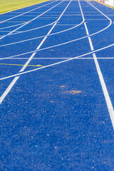 Blue running track at stadium with curved lanes and vibrant surface, inviting athletes to compete...