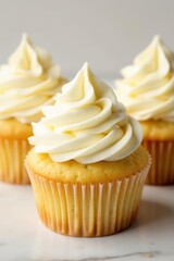 Fluffy vanilla cupcakes topped with creamy swirls of tangy cream cheese frosting , buttercream, tasty, sweet treat