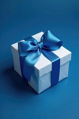 Obraz premium Gift box on a dark blue background with a large ribbon bow made of blue satin and white tissue paper wrapped around it, blue gift box, blue background, decorative box