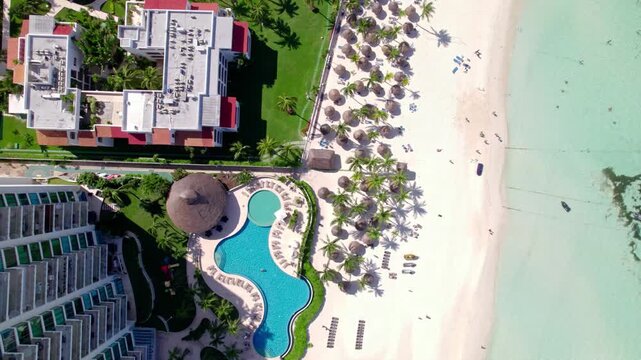 Top down beach with hotels, pool, and turqouise water 4K
