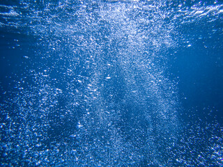Ocean blue underwater with sunrays, Underwater Sea Deep Water Abstract Sunshine, sea wave , clean waters in summer time, Natural underwater seascape, sand on ocean floor and water surface with sunligh