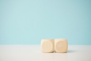 Two wooden cubes placed together against a blue background, featuring simple design and natural material appeal, versatile wooden cubes on clean background for business, health and education concepts.