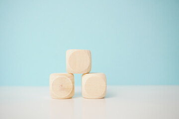 Three wooden blocks arranged in a pyramid against a soft blue background, showcasing natural materials and minimalism, for business, health and education concepts.