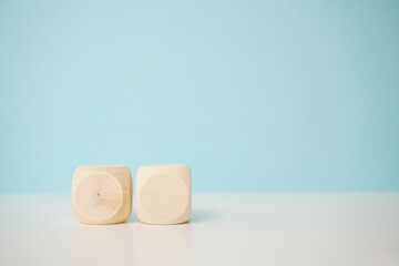 Close-up of two natural wooden cubes with a minimalistic pastel background, showcasing geometrical design and simplicity, for business, health and education concepts.
