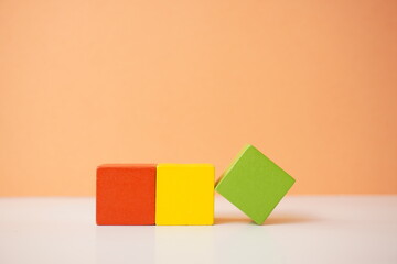 Vibrant red, yellow, and green wooden cubes creating a playful arrangement, versatile wooden cubes on clean background for business, health and education concepts.