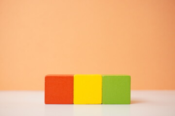 Three colorful wooden cubes arranged in a row, showcasing vibrant red, yellow, and green shades. Versatile wooden cubes on clean background for business, health and education concepts.