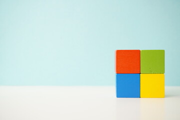 Colorful wooden blocks arranged neatly, showcasing creativity and minimalism, against a pastel blue...