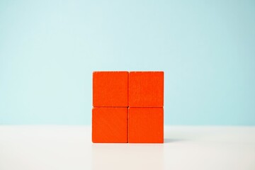 An arrangement of four bright orange wooden cubes on a light surface, showcasing symmetry and simplicity. Versatile wooden cubes on clean background for business, health and education concepts.