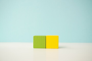Minimalistic composition of green and yellow blocks, symbolizing simplicity and creativity, versatile wooden cubes on clean background for business, health and education concepts.