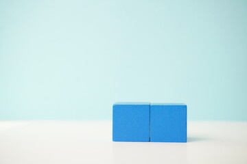 Blue wooden cubes aligned on a white surface against a light blue background, showcasing balance and simplicity, versatile wooden cubes on clean background for business, health and education concepts.