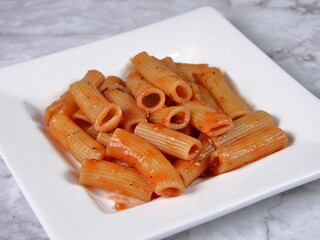 Rigatoni Pasta and Tomatoe Sauce on a White Plate
