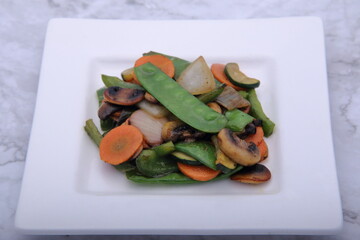 Stirfry Vegetables on white plate with Marble background.