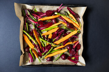 Beetroots, carrots and asparagus with olive prepared for roasting.