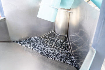 Plastic granules inside industrial recycling machine used for polymer manufacturing, raw material...