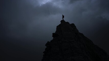 silhouette of a man standing on a rock - Powered by Adobe