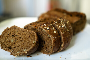 Sliced whole grain brown bread with seeds on plate.