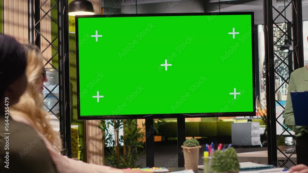 Poster multiethnic corporate staff gathers in front of a green screen tv display, preparing a pitch that wi