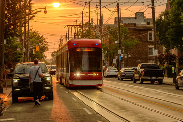 public transport: modern tram car on city street shot in the toronto beaches early on a hot  summer...