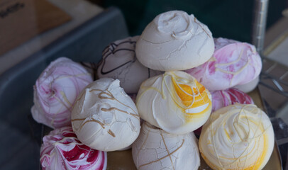 Delicious meringue cookies with various colors and chocolate toppings at a market stall in Weston...