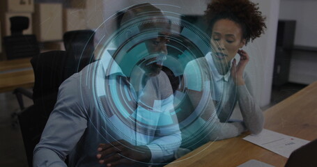 Collaborating professionals analyzing holographic interface in meeting room, with charts and laptop