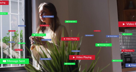 Holding smartphone woman standing at home, showing floating message, contact and media labels