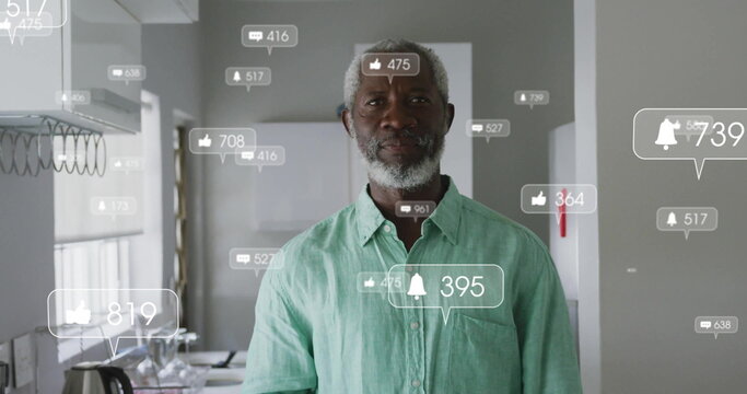 Standing mature African American man monitoring floating notifications in kitchen, with kettle, mug