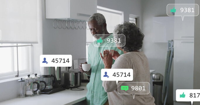 Sharing smartphone screen couple standing at home kitchen countertop, with coffee maker and mug